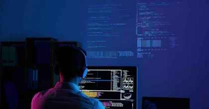 Ajax Nedir? Ajax Nerelerde Kullanılır? Temiz Kodlama ve Ajax Teknolojisi ile Geliştirilmiş WordPress Altyapısı Karanlık bir odada monitörlere bakan yazılımcı görseli; temiz kodlama ve Ajax teknolojisini simgeler